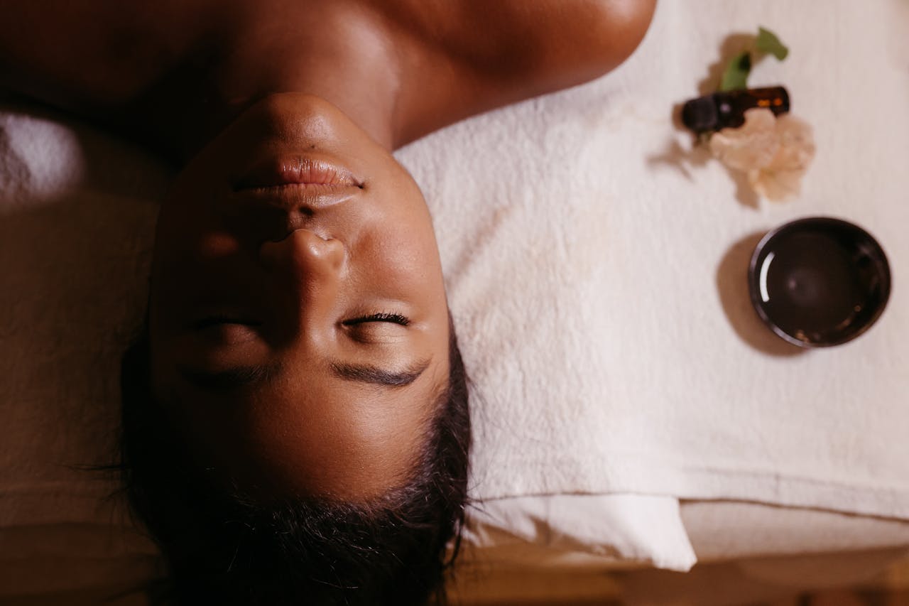 creative-03 Serene spa massage with a woman relaxing and essential oils, promoting wellness and tranquility.