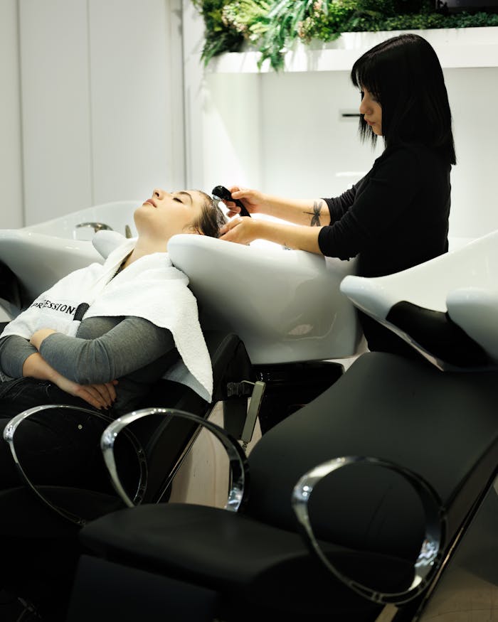 creative-02 Woman receiving a relaxing hair wash at a salon by a professional hairdresser.